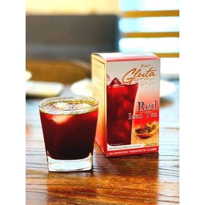 Glass of red tea next to a box of Red Iced Tea on a wooden surface.